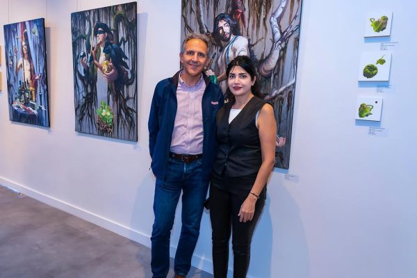 a man and woman standing in front of paintings