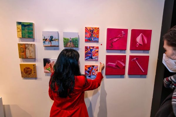 a woman in a red dress drawing on a wall