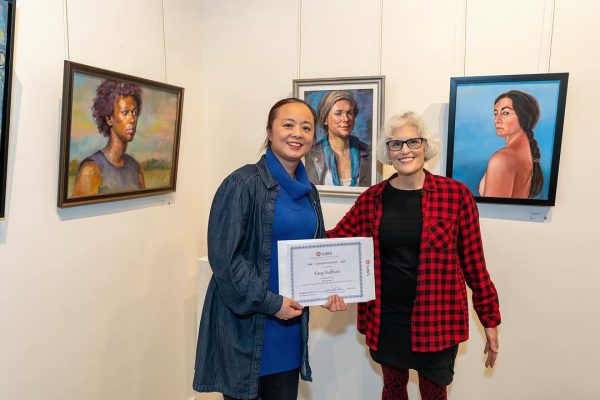 two women holding a certificate
