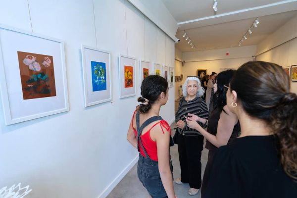 a group of women looking at art on a wall