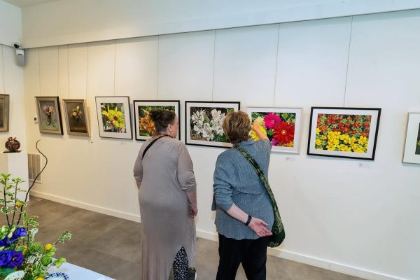 a group of women looking at pictures on a wall