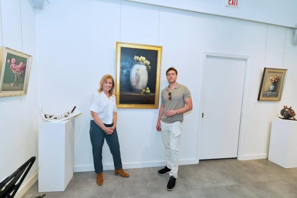 a man and woman standing in front of a painting
